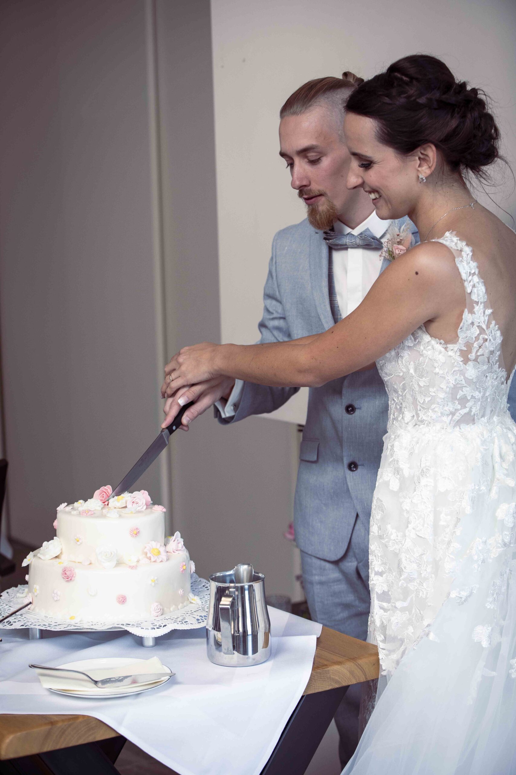 Brautpaar beim Anschneiden der Hochzeitstorte aus der ersten Perspektive