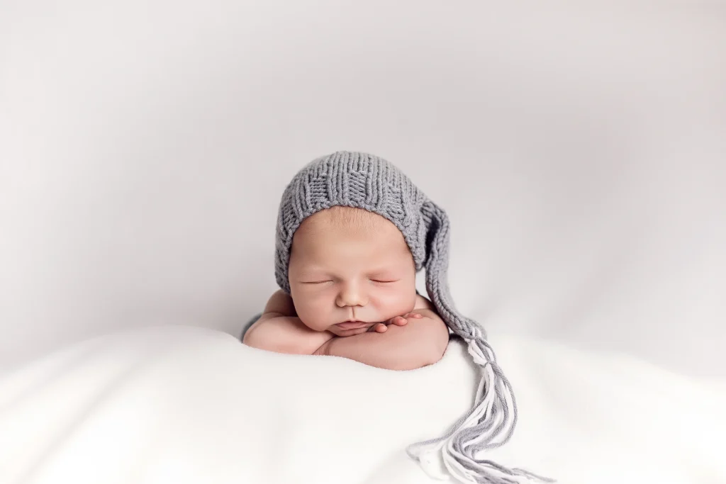 Schlafendes Baby mit grauer Strickmütze bei einem Newbornshooting
