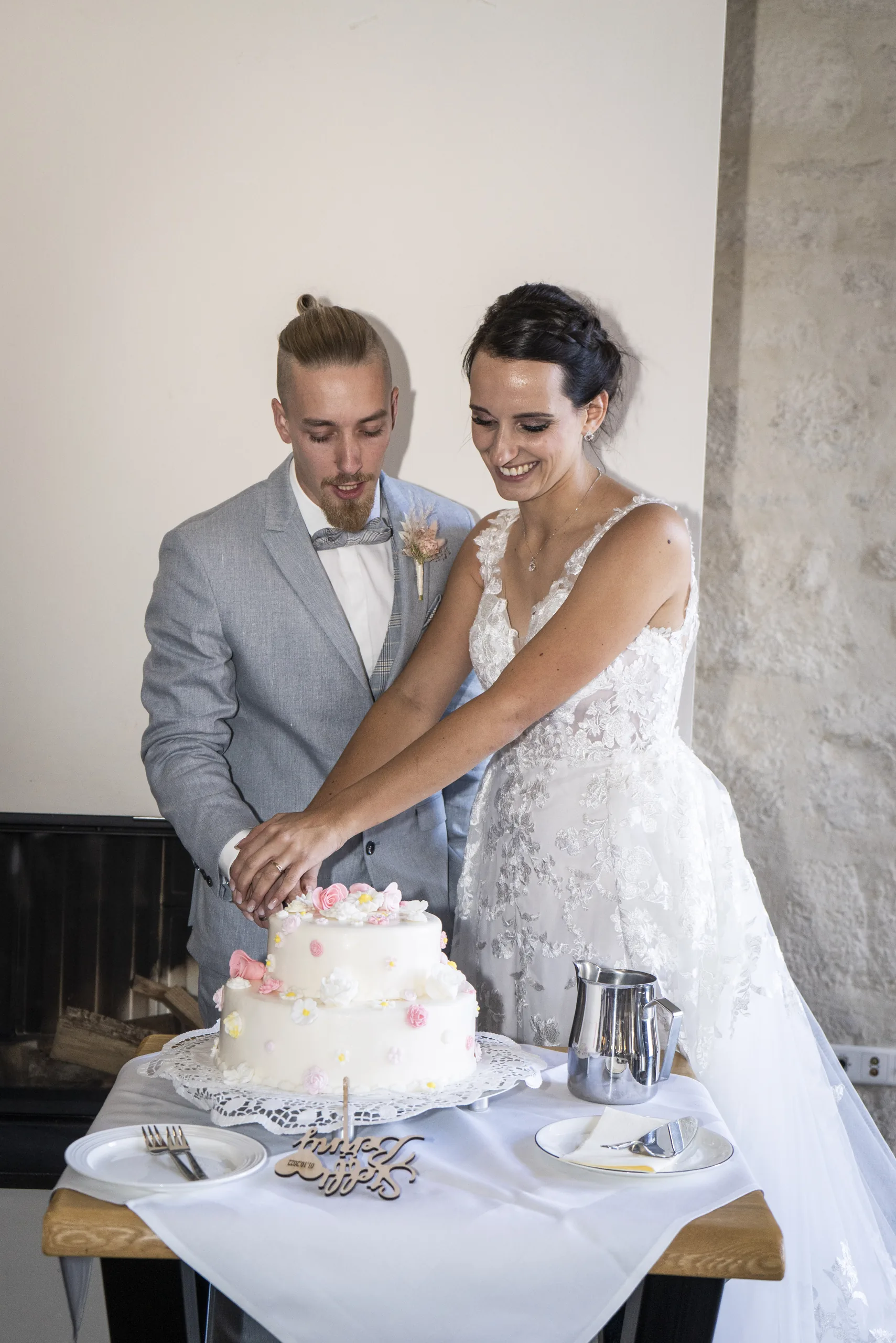 Brautpaar schneidet die weiße Hochzeitstorte auf Burg Scharfenstein an.