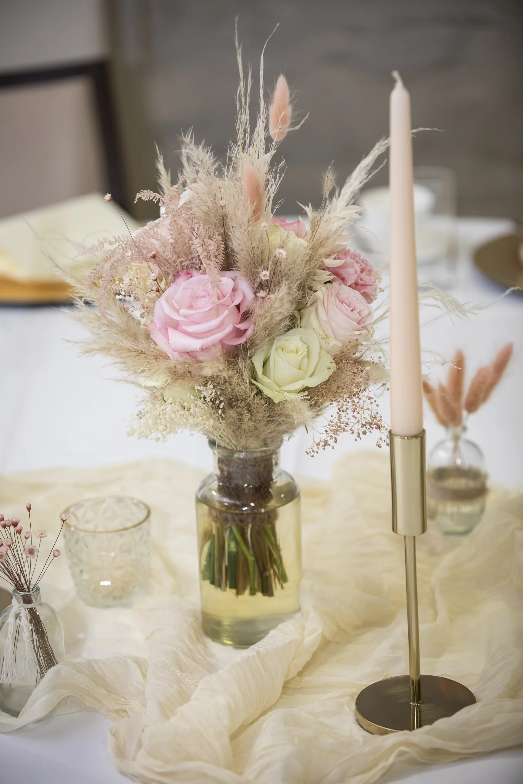 Rosa Blumenstrauß und Kerzen auf der Hochzeitstafel auf Burg Scharfenstein.