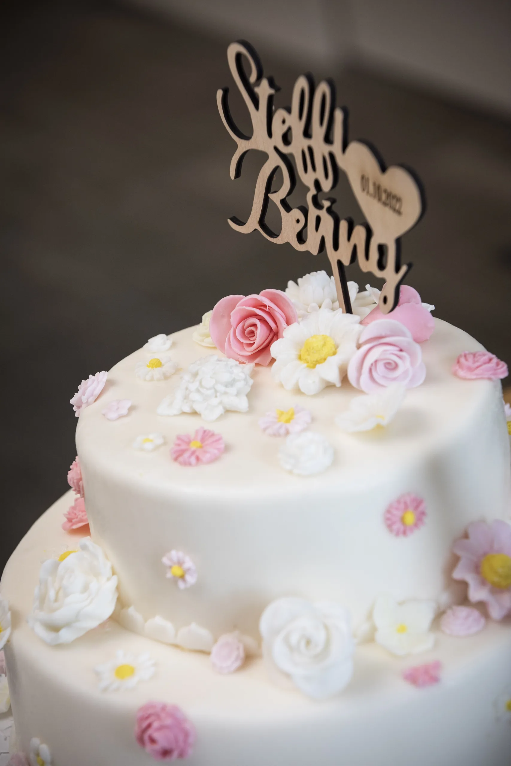 Weiße Hochzeitstorte mit rosa und weißen Zuckerblüten auf Burg Scharfenstein.