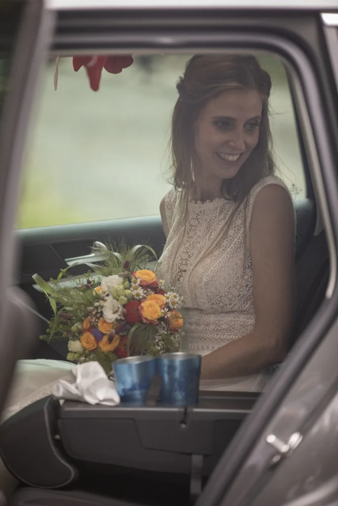 Braut mit Blumenstrauß im Auto an der Burgruine Hardenberg in Nörten-Hardenberg.