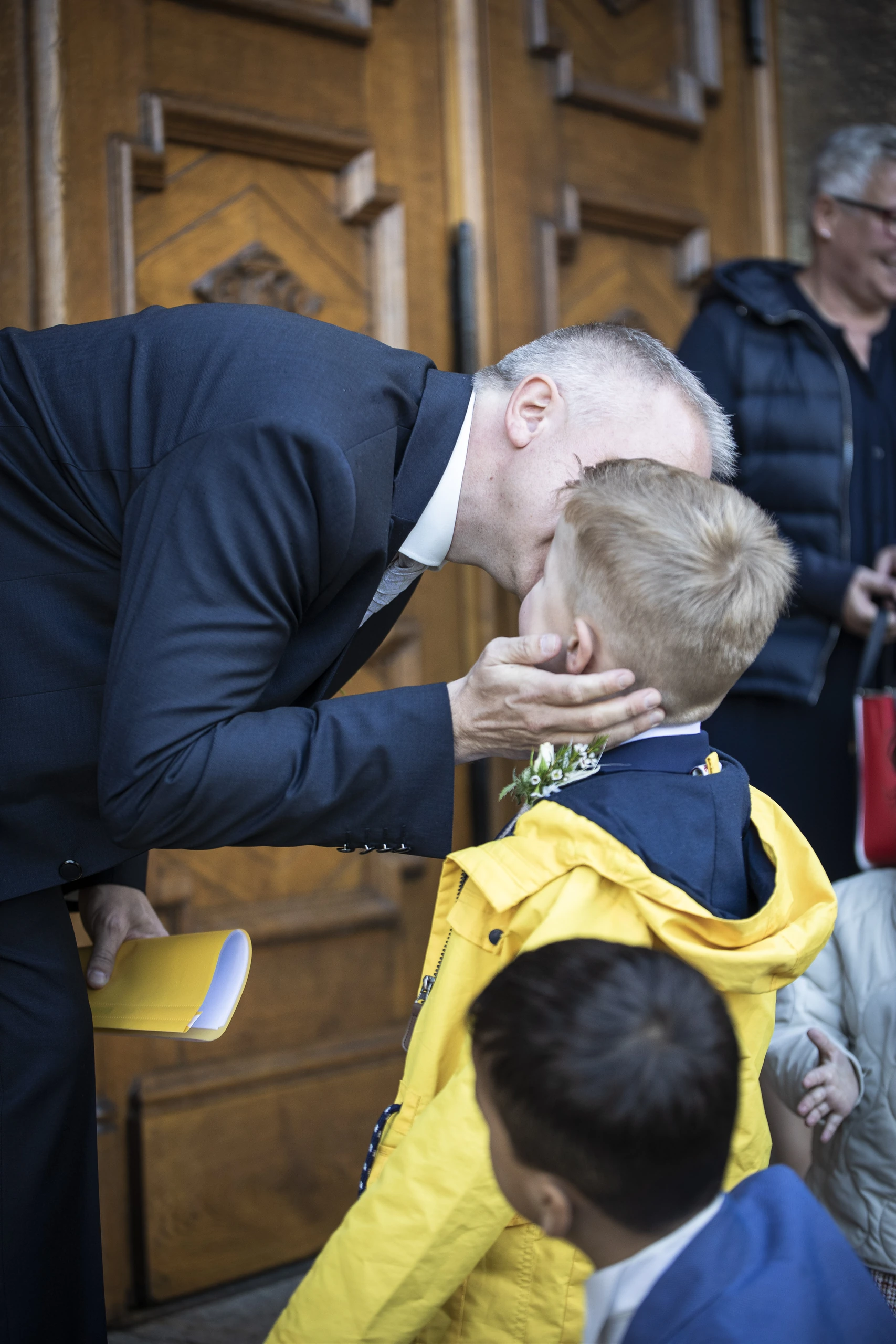 Bräutigam küsst einen kleinen Jungen am Eingang der Pfarrkirche St. Gerhard in Heilbad Heiligenstadt.