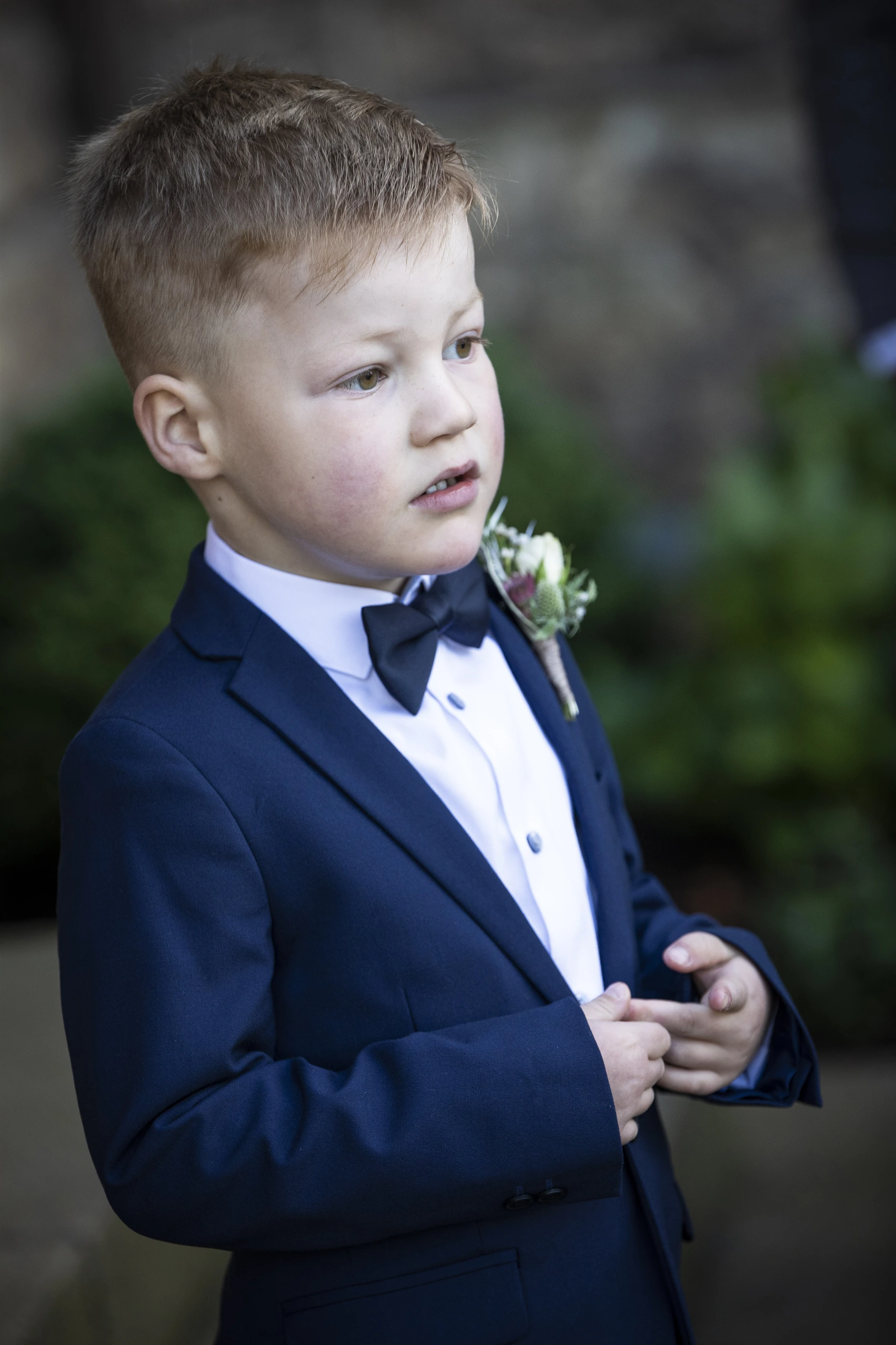 Kinderporträt eines Jungen im blauen Anzug mit Fliege an der Pfarrkirche St. Gerhard in Heilbad Heiligenstadt.