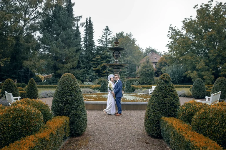Brautpaar vor einem Springbrunnen und Hecken auf Schloss Rheder in Brakel