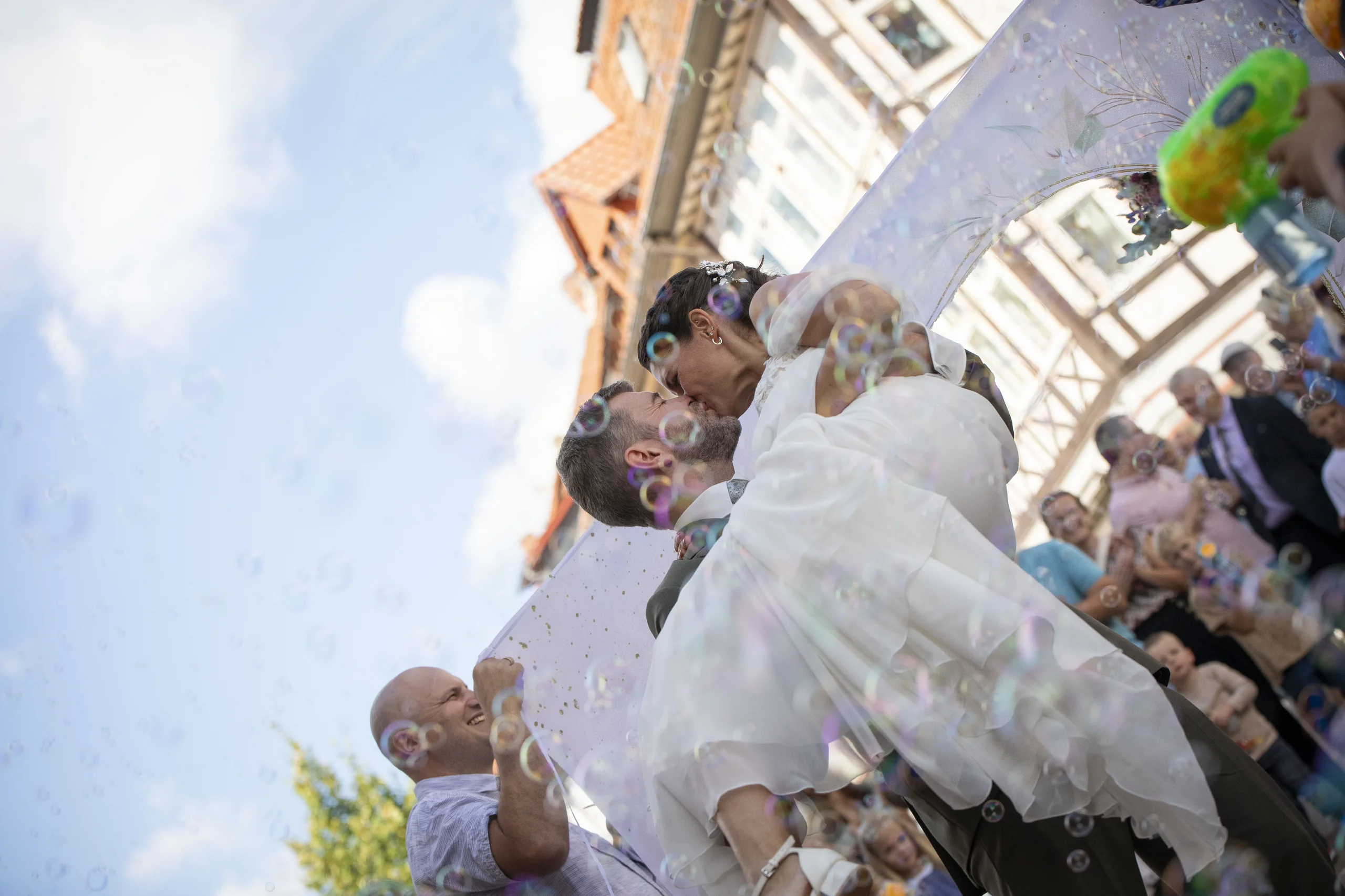 Bräutigam trägt die Braut durch ein ausgeschnittenes Herz bei der Hochzeit