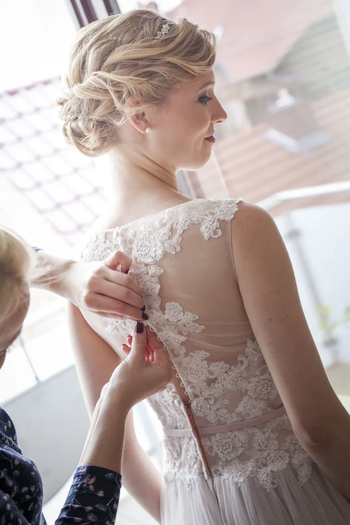 Ulrike beim Schließen ihres Spitzenkleids vor der Hochzeit in Heilbad Heiligenstadt