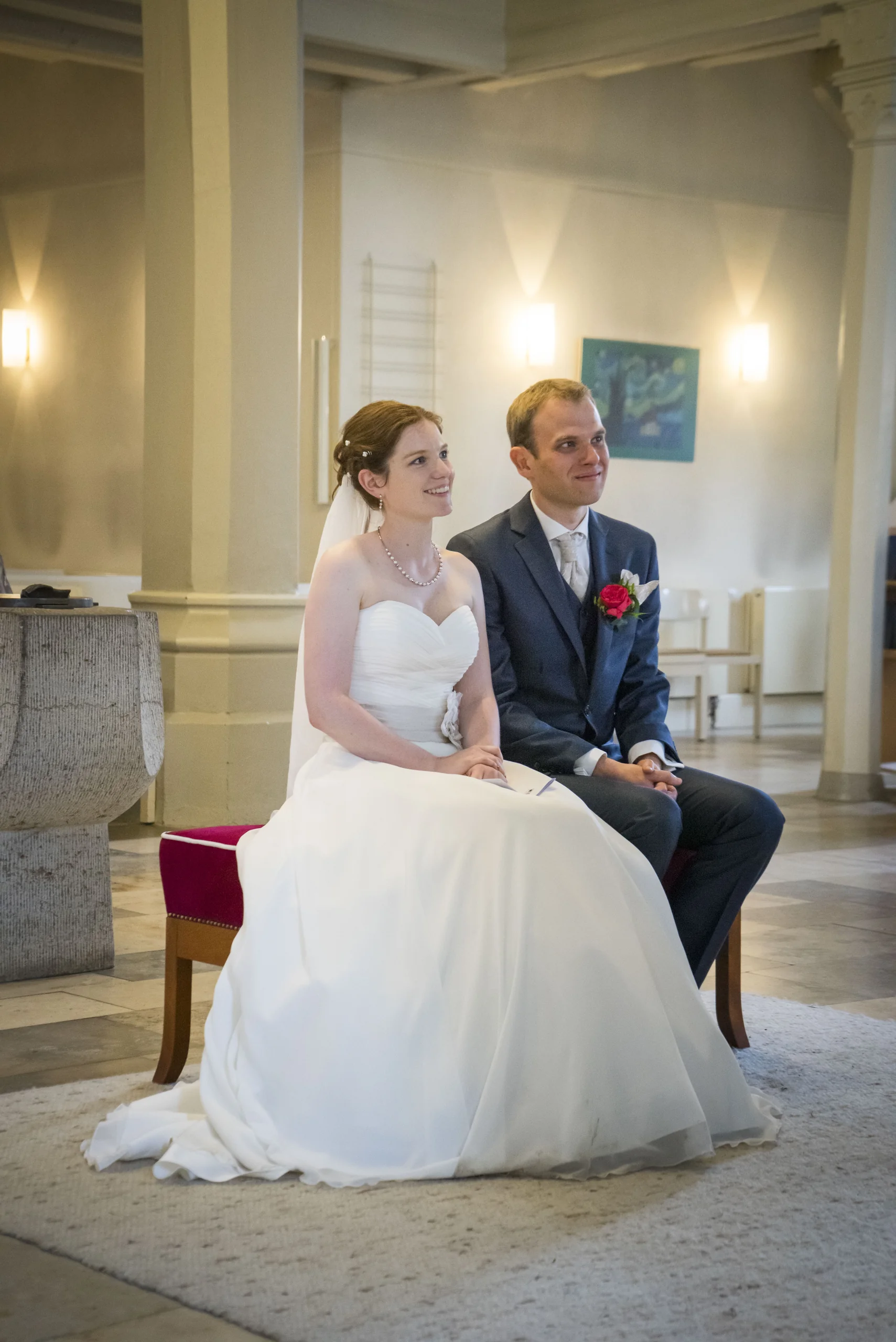 Timo und Franzi sitzen während ihrer Hochzeit vor dem Altar der St.-Martin-Kirche in Geismar