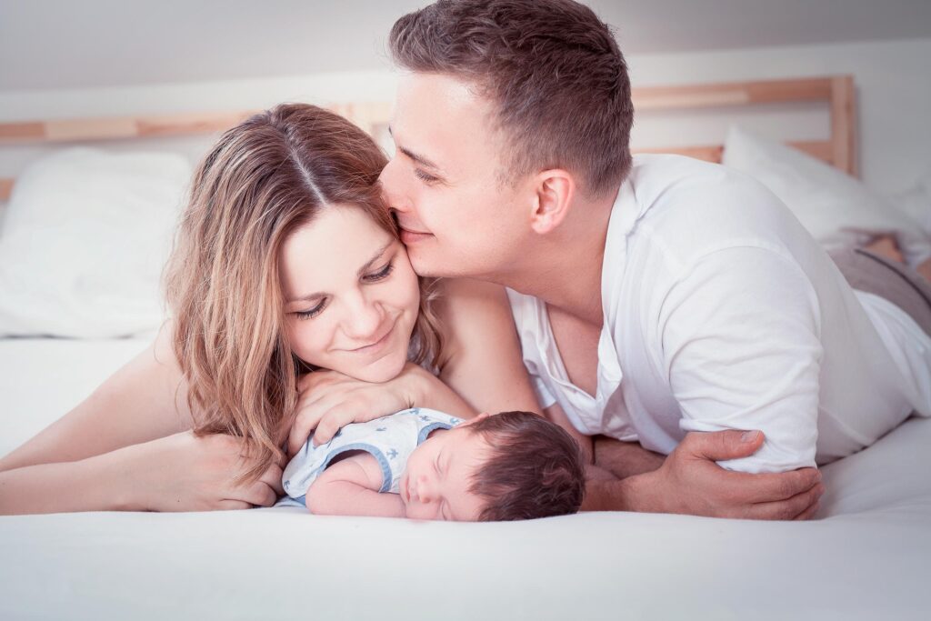 Eltern kuscheln zuhause mit ihrem neugeborenen Baby